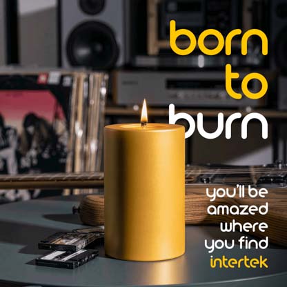 A lit candle sitting on a table next to various musical instruments