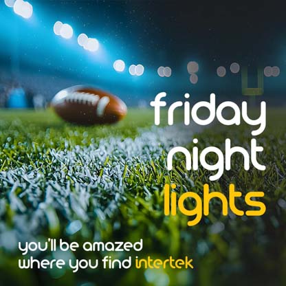 A football sitting on a field lit by strong lights